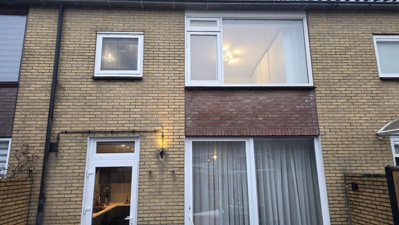 Voorgevel met vernieuwde kozijnen in de schemering